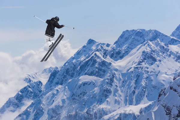 Létající lyžař na zasněžených horách. Extrémní zimní sport, sjezdové lyže. — Stock fotografie