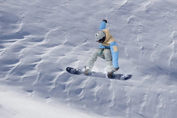 Сноубордист летит на фоне снежного склона. Экстремальные зимние виды спорта, сноуборд. — стоковое фото