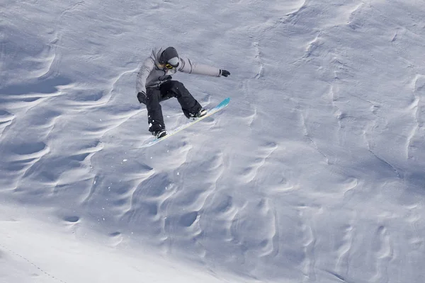 Snowboarder volando en el fondo de la pendiente nevada. Deportes extremos de invierno, snowboard. —  Fotos de Stock