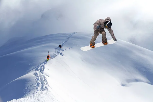 Skifahrer erklimmen einen verschneiten Berg — Stockfoto