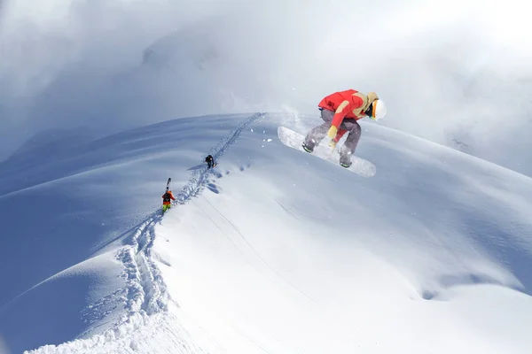 Skiërs een besneeuwde berg klimmen — Stockfoto