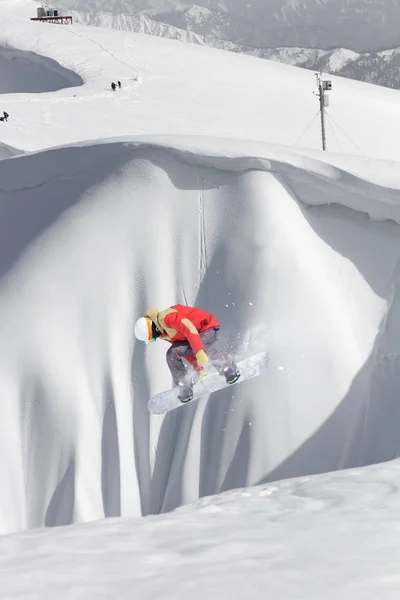 Snowboarder fliegt auf dem Hintergrund des schneebedeckten Hangs. Extremer Wintersport, Snowboard. — Stockfoto