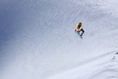 Karlı yamaçta uçan snowboardcu. Kış sporları, snowboard sporları.