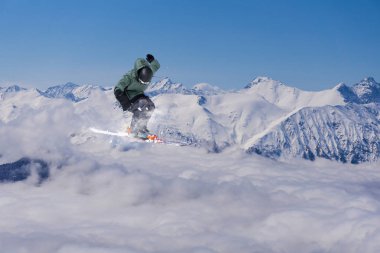 Karlı dağlar üzerinde uçan kayakçı. Aşırı kış sporları, Kayak.