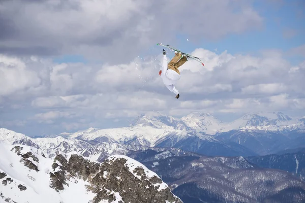Létající lyžař na zasněžených horách. Extrémní zimní sport, sjezdové lyže. — Stock fotografie