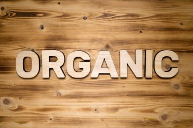 Tahta tahtadaki ahşap blok harflerinden yapılmış ORGANIC kelimesi.