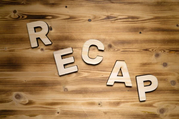 木製の板に木製のブロック文字で作られたRecap単語 トップビュー — ストック写真