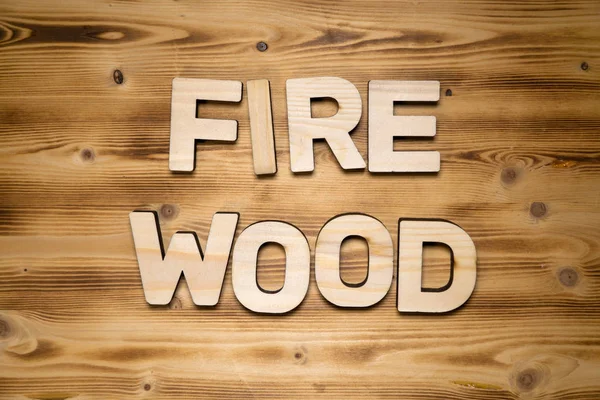 FIREWOOD word made of wooden block letters on wooden board. — Stock Photo, Image