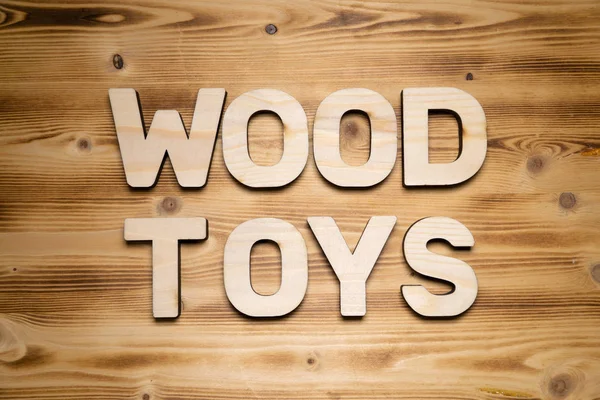 WOOD TOYS words made of wooden block letters on wooden board.