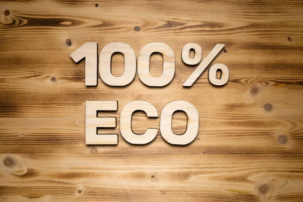 100% ECO words made of wooden letters on wooden board . — стоковое фото