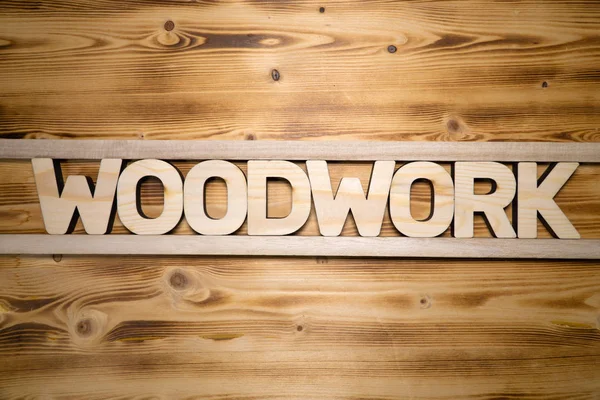 Holzarbeit Wort mit Bausteinen auf Holzbrett — Stockfoto