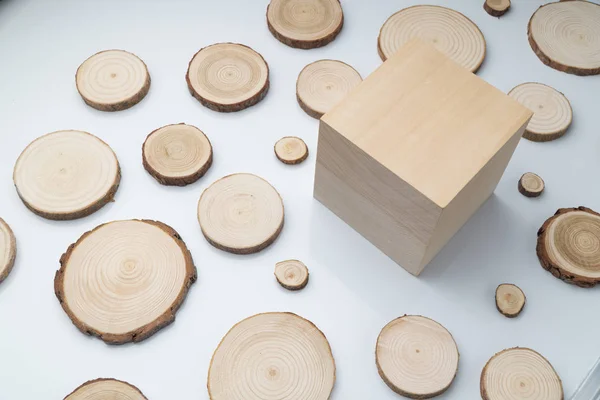Secções transversais de pinheiro com anéis anuais e cubo de madeira na superfície branca plana. Peça de madeira close-up . — Fotografia de Stock