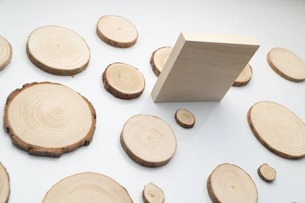 Secções transversais de pinheiro com anéis anuais e quadrado de madeira na superfície branca. Peça de madeira close-up . — Fotografia de Stock
