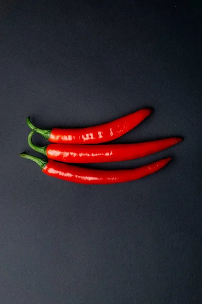 Zöld és piros chili paprika, fekete háttér felülnézet. Forró fűszeres ételek. — Stock Fotó