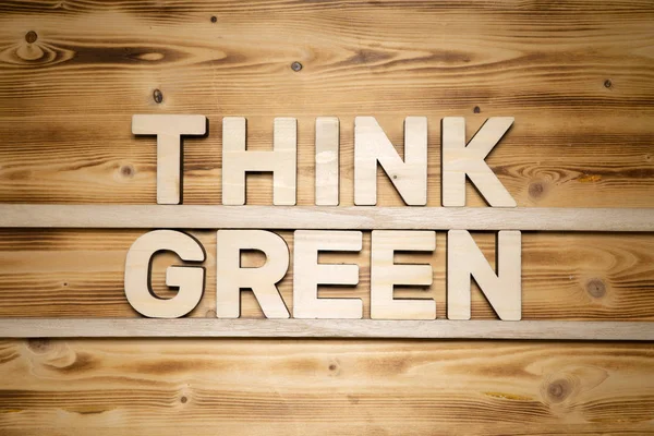 Denken grüne Wörter aus Holzbuchstaben auf Holzbrettern. — Stockfoto