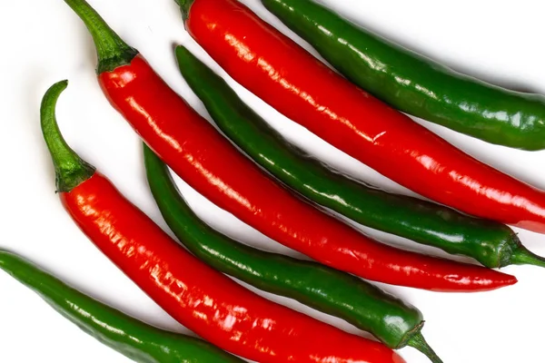 Κάτοψη του πράσινες και κόκκινες πιπεριές τσίλι σε άσπρο φόντο. Καυτά πικάντικα τρόφιμα. — Φωτογραφία Αρχείου