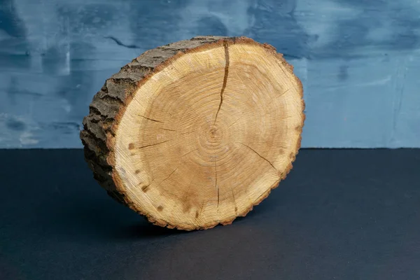 Corte transversal da árvore rachada com anéis anuais sobre fundo azul pintado. Peça de madeira close-up. — Fotografia de Stock