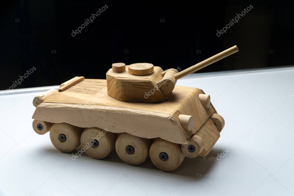 Wood tank on black background. Wooden toy tank studio shot.