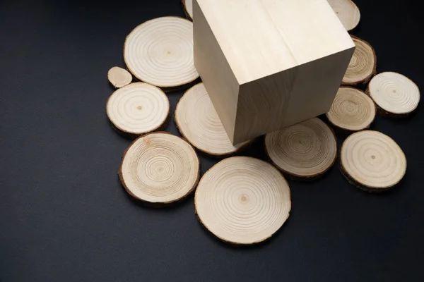 Pine tree průřezy s letokruhy a dřevěné kostky na černém povrchu. Dřevo kus detail. — Stock fotografie
