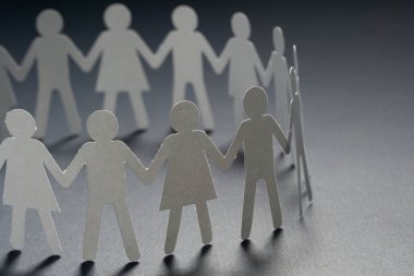 Karanlık yüzey üzerinde el ele tutuşarak kağıt insanların daire. Topluluk, sendika kavramı. Toplum ve destek.