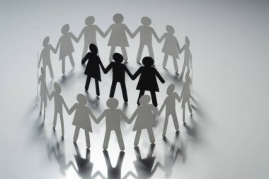 Üç insan kağıt rakamlar beyaz yüzey üzerinde el ele tutuşarak kağıt insanların daire çevrili. Bulling, segregasyon, çatışma kavramı.