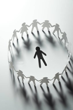 Kağıt lider figürü önünde kırmızı yüzey üzerinde el ele tutuşarak kağıt insanlar. Lider, politikacı, patron.
