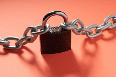 Pembe artalan üzerinde zincirleri çapraz manzaralı asma kilit kilitli.