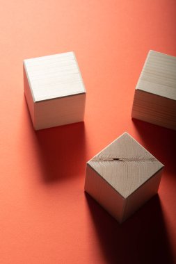 Üç ahşap küp kırmızı bir arka plan üzerinde. Grup geometrik şekiller, üstten görünüm
