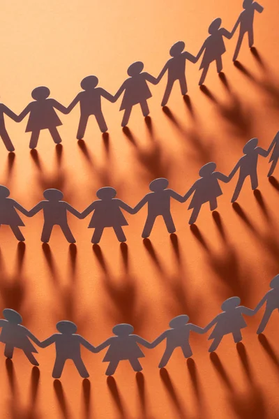 Paper people holding hands on red surface. Community, union concept. Society and support. — Stock Photo, Image