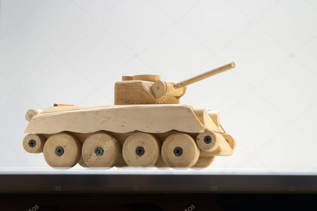 Wood tank on black background. Wooden toy tank studio shot.