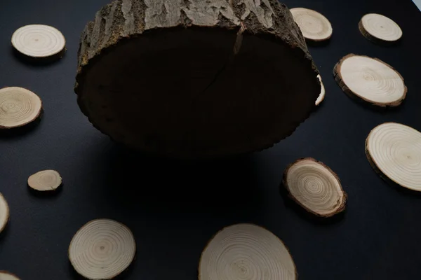 Secções transversais de pinheiro com anéis anuais sobre fundo preto. Peça de madeira close-up . — Fotografia de Stock