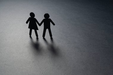 Siyah kağıt birkaç tutuşup gri yüzeyi figürü. Yalnızlık, çocuksuz, yaşlılık kavramı.