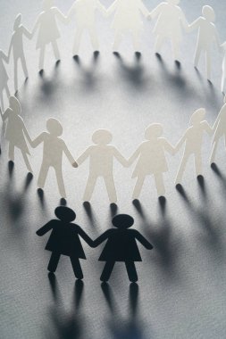 Kağıt kadın çift daire dışında gri yüzey üzerinde el ele tutuşarak kağıt insan figürü. Bulling, azınlıklar, çatışma kavramı.