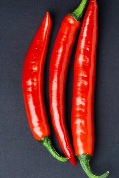 Green and red chili peppers on black background top view. Hot spicy food. — Stock Photo, Image