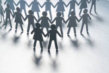 Siyah kağıt bir kalabalığın önünde bir çift beyaz yüzey üzerinde el ele tutuşarak kağıt insan figürü. Toplumsal hareket, liderlik, protesto kavramı.