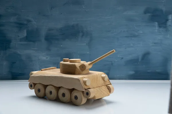 Dřevěný tank na modré malované pozadí. Dřevěná hračka tank studio zastřelil. — Stock fotografie