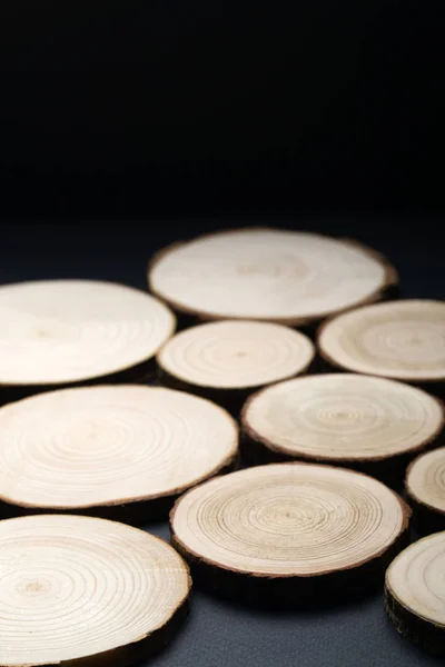 Coupes transversales de pins avec anneaux annuels sur surface noire plane. Pièce de bois gros plan . — Photo