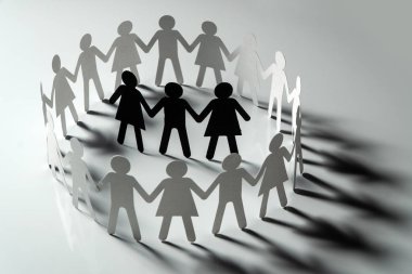Üç insan kağıt rakamlar beyaz yüzey üzerinde el ele tutuşarak kağıt insanların daire çevrili. Bulling, segregasyon, çatışma kavramı.