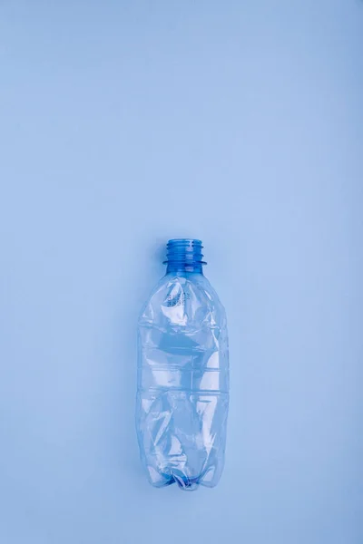 Schiantato bottiglia di plastica su sfondo blu brillante. Concetto di utilizzo della plastica. Problema ecologico, ambiente globale . — Foto Stock