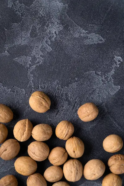 Manojo de nueces enteras sobre fondo de pizarra azul oscuro. Composición saludable de la dieta . —  Fotos de Stock