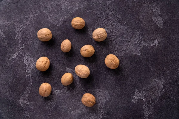 Manojo de nueces enteras sobre fondo de pizarra azul oscuro. Composición saludable de la dieta . — Foto de Stock