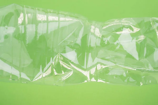 Zertrümmerte Plastikflasche auf grünem Hintergrund. Kunststoffnutzungskonzept. ökologisches Problem, globale Umwelt. — Stockfoto