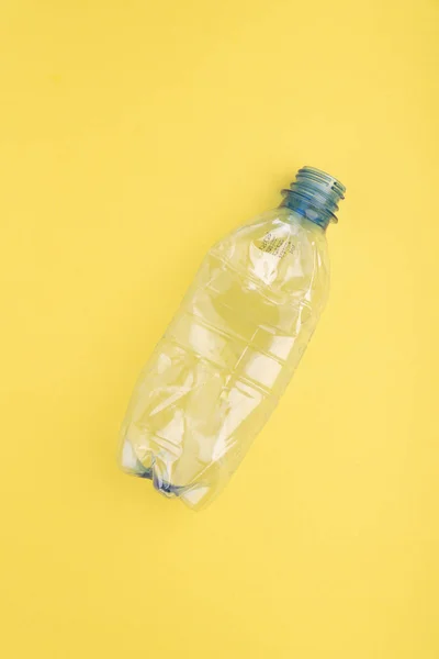 Crashed plastic bottle on yellow background. Plastic utilisation concept. Ecological problem, global environment. — Stock Photo, Image