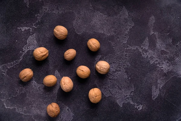 Koyu mavi kayrak arka planda bütün ceviz demet. Sağlıklı beslenme kompozisyonu.