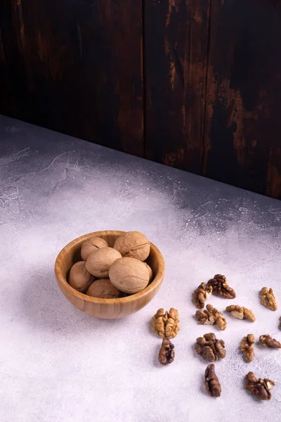 Nueces en cuenco de madera sobre superficie texturizada brillante. Composición saludable de frutos secos y semillas . —  Fotos de Stock