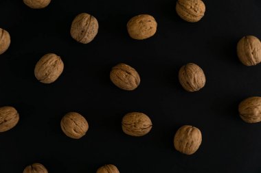 Ceviz siyah yüzey, üst görünümü üzerinde kabuk içinde. Yuvarlak ceviz arka plan. Sağlıklı fındık ve tohum bileşimi.