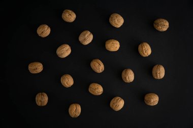 Ceviz siyah yüzey, üst görünümü üzerinde kabuk içinde. Yuvarlak ceviz arka plan. Sağlıklı fındık ve tohum bileşimi.