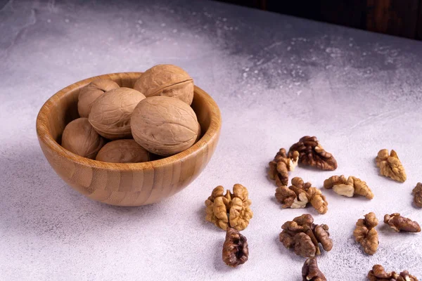 Nueces en cuenco de madera sobre superficie texturizada brillante. Composición saludable de frutos secos y semillas . —  Fotos de Stock