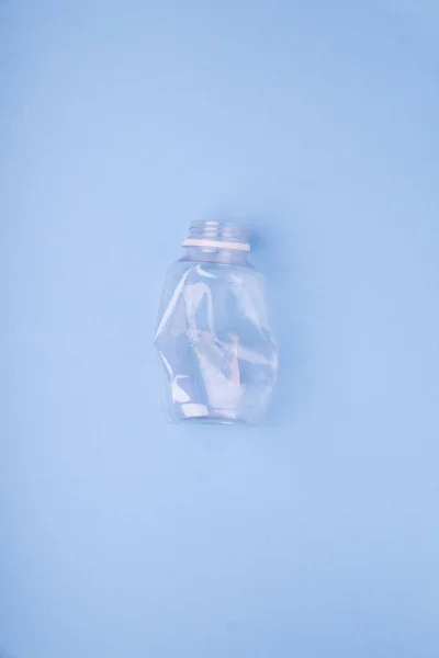 Bater garrafa de plástico no fundo azul brilhante. Conceito de utilização de plástico. Problema ecológico, ambiente global . Imagens De Bancos De Imagens