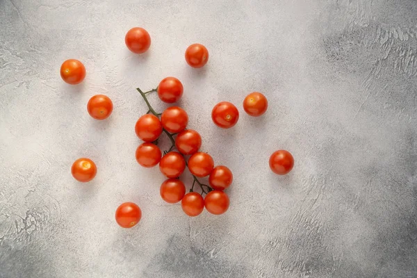 Bukiet pomidorków wiśniowych na białym kamiennym stole betonowym, widok z góry z przestrzenią kopiowania. Składniki do gotowania. — Zdjęcie stockowe